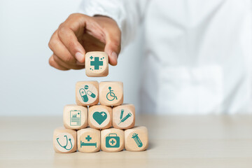 Concept of medical and healthcare. Doctor holding wooden cube blocks stacking with medical icons. treatment and medicine symbol signs.