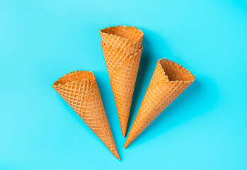A set of waffle cones for ice cream on a light blue background. Top view, horizontal