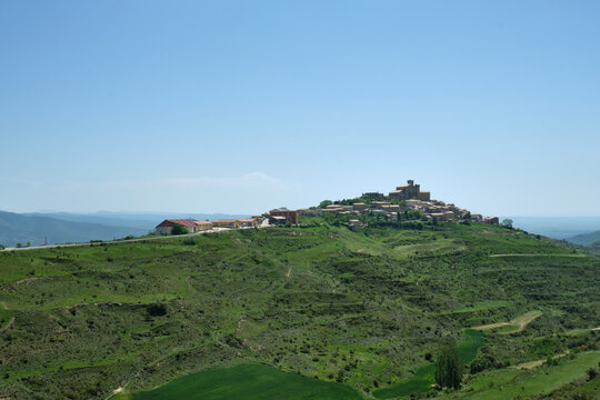 village of Uju&eacute; on top of a green hill in the sierra de Ujue, Navarra, Spain