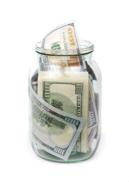 Many 100 US dollars bank notes in a glass jar isolated on white background