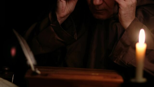 Video of old monk takes a manuscript out of the document box, signs it and puts it back.