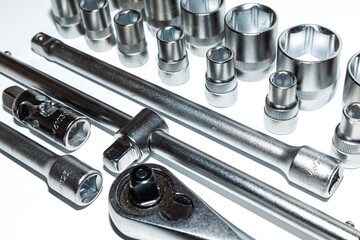 A set of new tools on a white background. Set of adjustable wrenches with handle holder, adapters and extensions and detachable sockets.