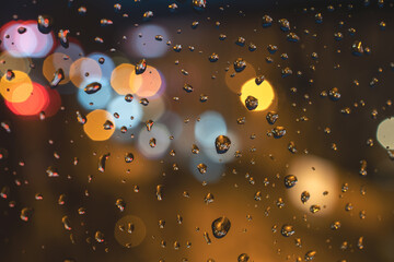 Raindrops on blue glass background. Street bokeh out of focus.  abstract background