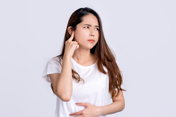 Young asian woman with facial piercing holding finger at her ear. She having painful grimace, frowning, posing isolated on white background