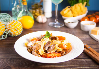 Traditional italian seafood pasta on white plate with clams vongole with tomatoes and basil. Tasty and delisious food.