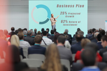 Professional man presenting a business plan at a conference and people listening