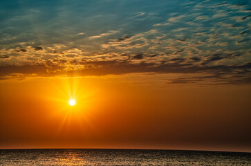 Beautiful sunset at sea, with cloudy sky