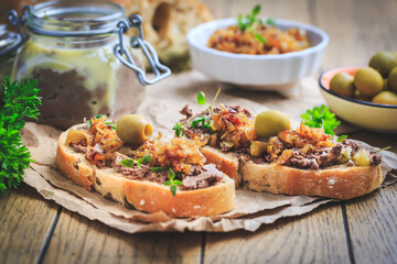 Fresh homemade chicken liver pate on ciabatta bread with roasted onions and olives