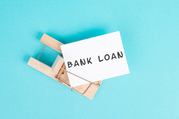 Paper with the words bank loan in a mousetrap, finanicial debt, inflation, risky credit and...
