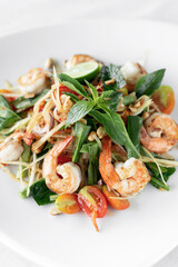 thai som tam spicy papaya salad with prawns on white background