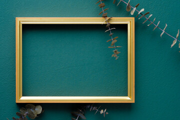 photo frame mockup with eucalyptus branch on green table