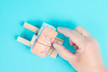 Euro banknotes in a mousetrap, bank loan, finanicial debt, inflation, risky credit and investment,...