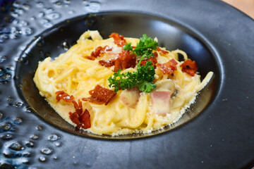 Carbonara pasta with hard parmesan cheese and cream sauce.