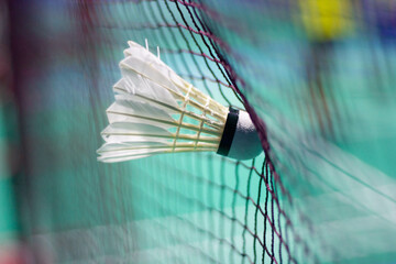 The shuttlecock is floating in a green badminton court net. background shot in low light	