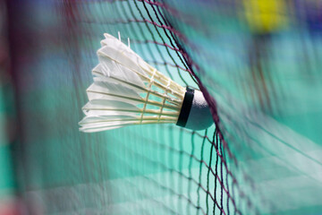 The shuttlecock is floating in a green badminton court net. background shot in low light