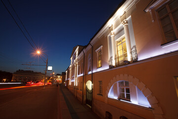 Fototapeta premium Moscow, Russia - July, 27 2014: Historical building in Moscow center at night. Mansion (right) and road with traces of lights (left).