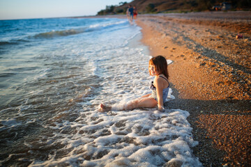 European girl child alone on the seashore, wide angle shooting, vacation with children at sea