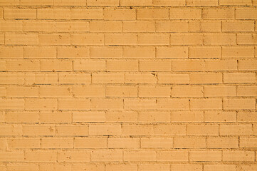 Simple textured light background of wall of building with orange bricks in city