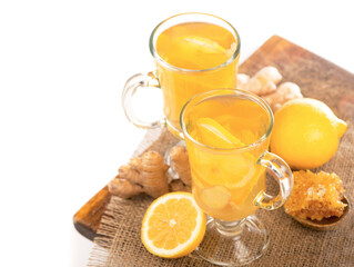 Ginger tea with lemon and honey in crystal glass on wooden table