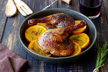 Baked duck legs with oranges and rosemary. Rustic style.