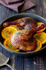 Baked duck legs with oranges and rosemary. Rustic style.