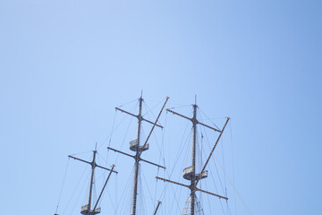 Ship mast and rigging without sails on a blue sky
