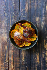 Baked duck legs with oranges and rosemary. Rustic style.