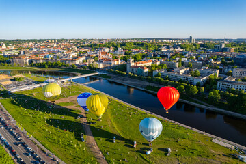 Aerial spring evening view of rising hot air balloons over the city of Vilnius, Lithuania - obrazy, fototapety, plakaty