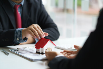 Signing a home loan purchase agreement with a real estate agent.