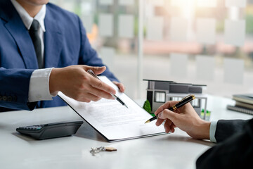 Signing a home loan purchase agreement with a real estate agent.