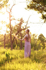 Obraz premium a gentle woman at sunset in nature. fabulous light.