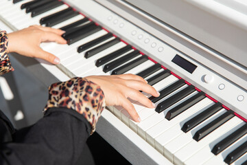 Hands of a female artist playing the piano. Woman pianist making music with piano.