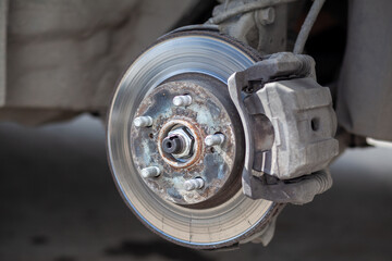 Disc brake of the vehicle for repair, in process of new tire replacement. Car brake repairing in...
