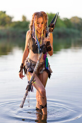 amazon woman in a fur medieval costume with a spear in her hand, in war paint, fords the river.