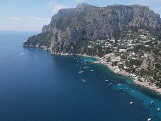 Fototapeta premium Aerial view of Capri, an island on the south side of the Gulf of Naples in the Campania region of Italy. Drone view of Faraglioni di Capri. 