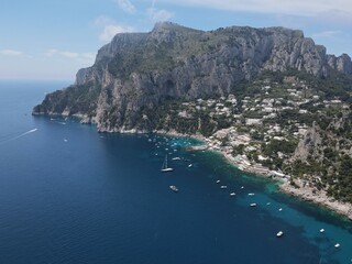 Fototapeta premium Aerial view of Capri, an island on the south side of the Gulf of Naples in the Campania region of Italy. Drone view of Faraglioni di Capri. 
