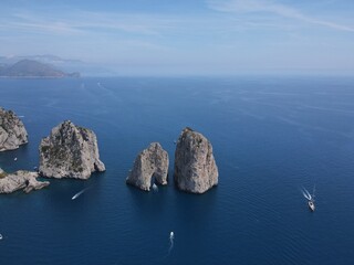 Aerial view of Capri, an island located in the Tyrrhenian Sea off the Sorrento Peninsula, on the south side of the Gulf of Naples in the Campania region of Italy. Drone view of Faraglioni di Capri.