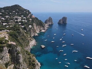 Aerial view of Capri, an island located in the Tyrrhenian Sea off the Sorrento Peninsula, on the south side of the Gulf of Naples in the Campania region of Italy. Drone view of Faraglioni di Capri.