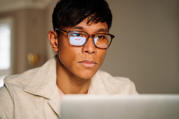 Asian Male working online with glasses