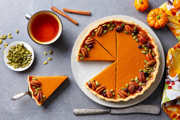 Pumpkin pie, tart with cup of tea. Grey stone background. Close up. Top view.