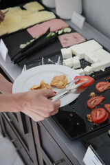 Woman taking food from a buffet line	