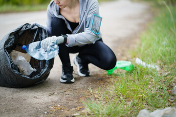 Plogging concept. Adult woman picking up garbage. Eco run.