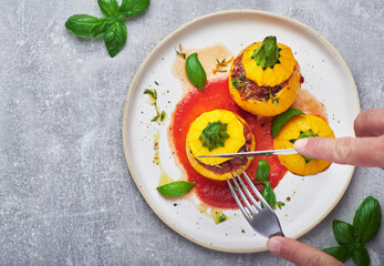 Stuffed zucchini. Round yellow zucchini stuffed with meat and vegetables served on plate.
