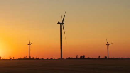 Wind turbine farm over sunset. Green Energy. Wind generators turbines at sunrise.