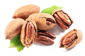 Shelled and cracked pecan nuts with leaves close-up on white background.