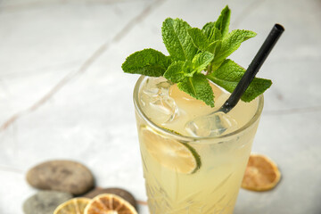 non-alcoholic cocktail, lemonade. With mint, ice, lime on a gray table