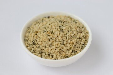 Raw hemp kernels in a small plate on a white background. Omega 3