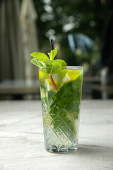 non-alcoholic cocktail, lemonade. With mint, ice, lime on a gray table