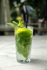 non-alcoholic cocktail, lemonade. With mint, ice, lime on a gray table