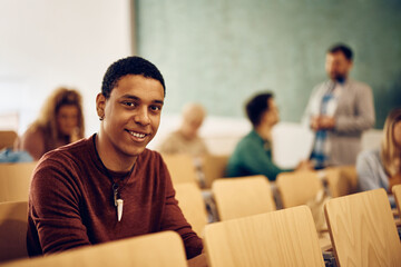Happy black student during class at college looking at camera.